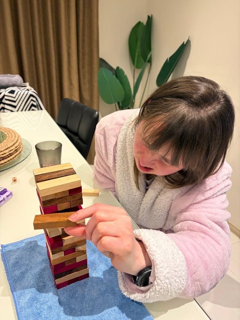 MindOn Care participant enjoying a supported Jenga activity