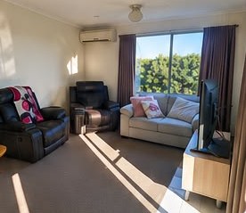 Comfortable lounge room of the Warrnambool SIL home with recliners and TV